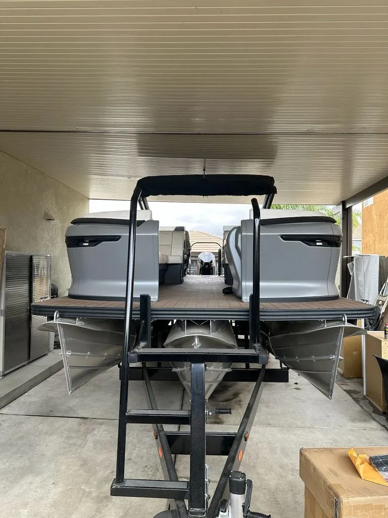 Slide: The Image of 2024 Manitou Switchback pontoon boat parked in a garage. - 5