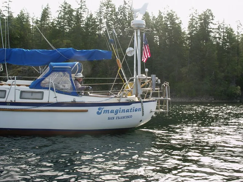 Slide: The Image of 1980 Pacific Crealock 37 sailboat on calm water, forest in background. - 2