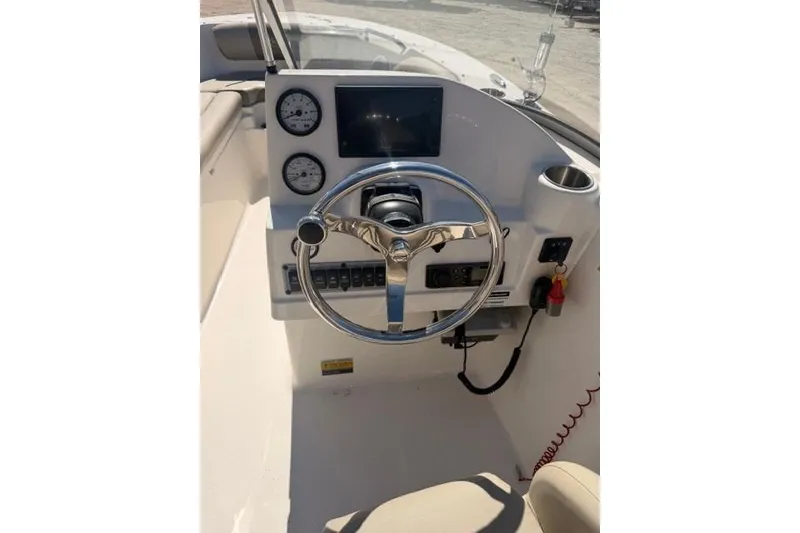 Slide: The Image of 2021 Key West 203 DFS boat dashboard with steering wheel and gauges. - 7