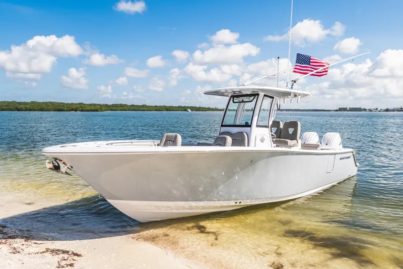 The Image of 2026 Sportsman Open 262 Center Console boat on sandy shore with American flag. - 0