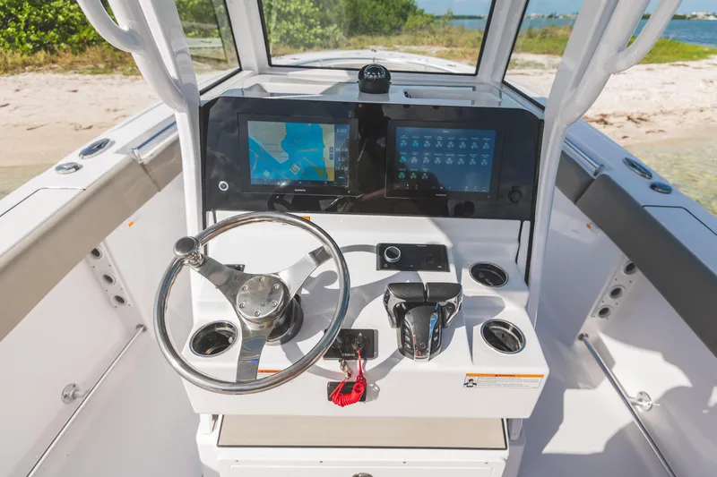 Slide: The Image of 2026 Sportsman Open 262 Center Console boat dashboard with navigation screens and steering wheel. - 15