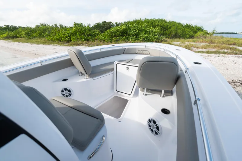 Slide: The Image of 2026 Sportsman Open 262 Center Console boat interior with seating and storage, near a sandy shore. - 17