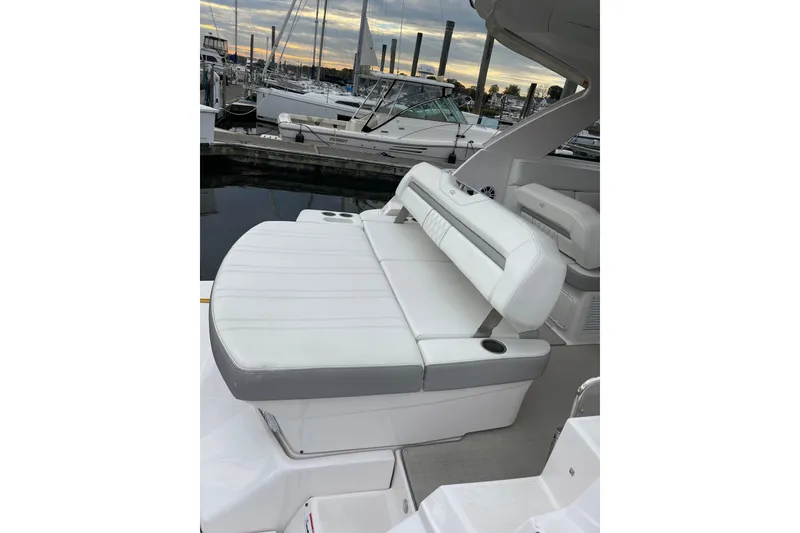 Slide: The Image of 2012 Regal 35 Sport Coupe boat with white seating at marina, showcasing luxury and comfort. - 11