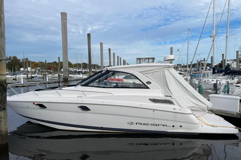 Slide: The Image of 2012 Regal 35 Sport Coupe yacht docked at marina under cloudy sky. - 12