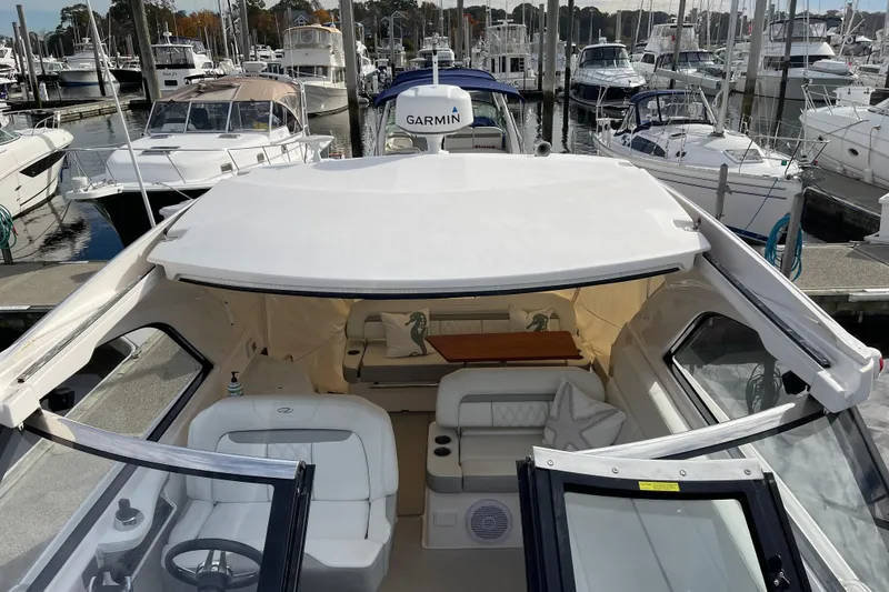 Slide: The Image of 2012 Regal 35 Sport Coupe yacht interior at marina, showcasing luxury seating and helm. - 17