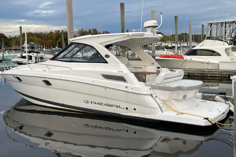 Slide: The Image of 2012 Regal 35 Sport Coupe yacht docked at marina, showcasing sleek design and luxury features. - 2