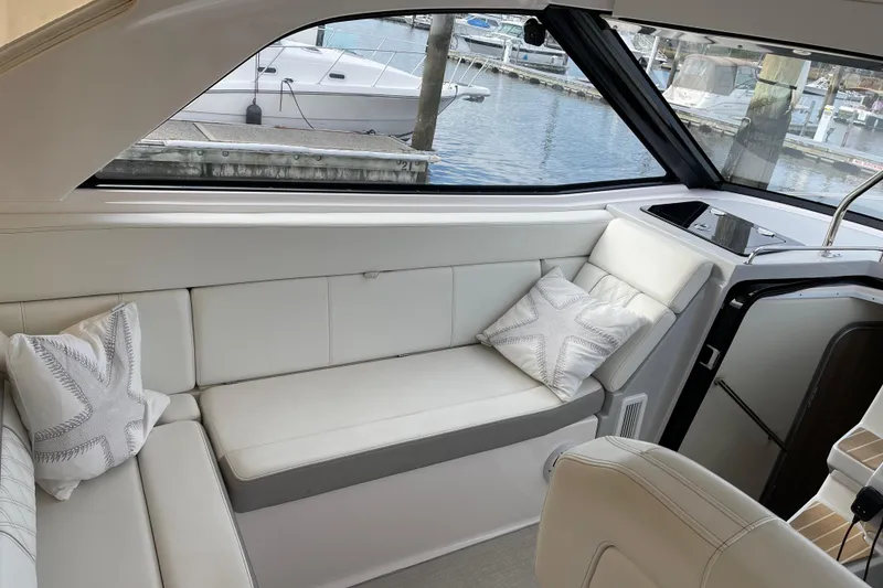 Slide: The Image of Interior of a 2012 Regal 35 Sport Coupe yacht with white seating and decorative pillows. - 21