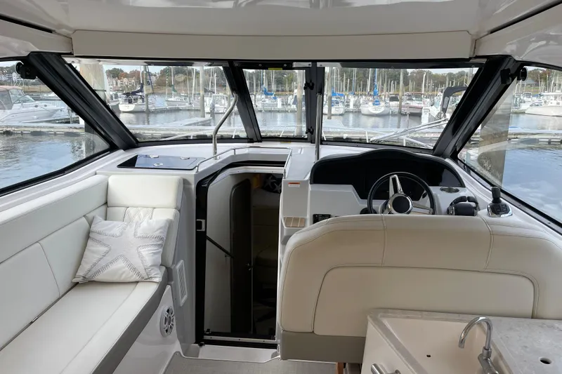 Slide: The Image of Interior view of 2012 Regal 35 Sport Coupe yacht at marina, featuring helm and seating area. - 25