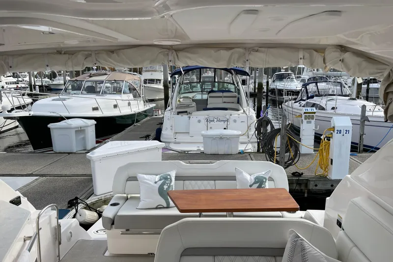 Slide: The Image of 2012 Regal 35 Sport Coupe at marina, featuring elegant seating and docked boats. - 26