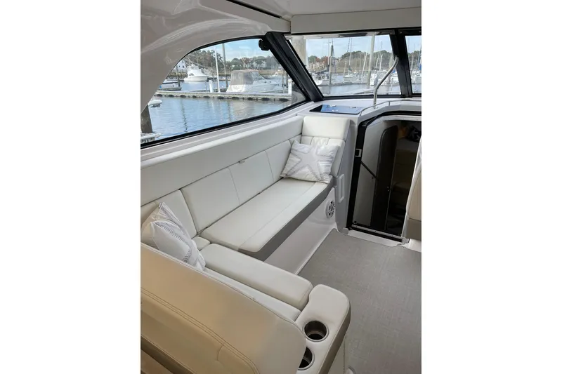 Slide: The Image of Luxurious interior of 2012 Regal 35 Sport Coupe yacht with white seating and marina view. - 27