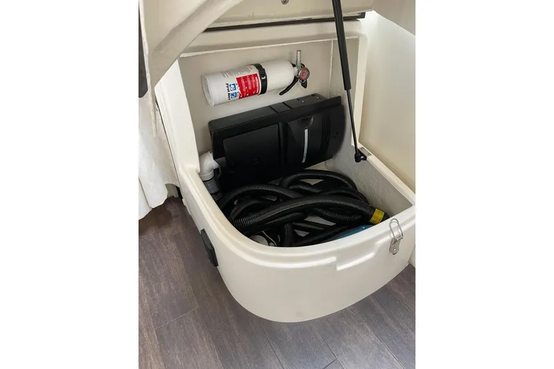 Slide: The Image of Storage compartment in a 2012 Regal 35 Sport Coupe with hoses and fire extinguisher. - 46