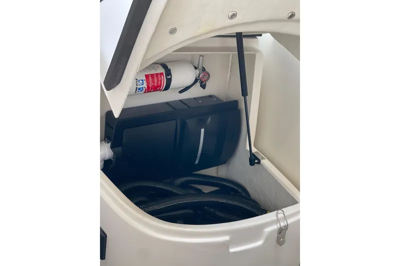 Slide: The Image of Storage compartment in a 2012 Regal 35 Sport Coupe with fire extinguisher and hoses. - 48