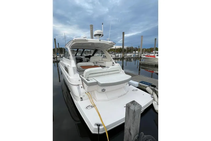 Slide: The Image of 2012 Regal 35 Sport Coupe yacht docked at marina under cloudy sky. - 54