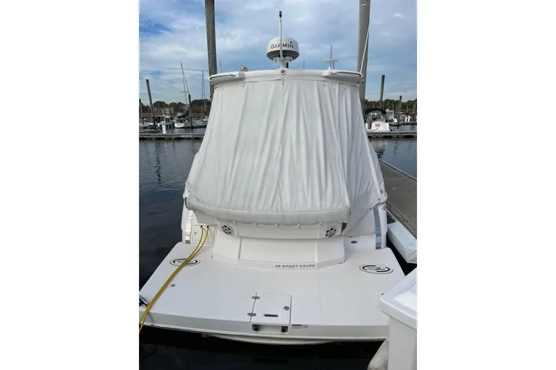Slide: The Image of 2012 Regal 35 Sport Coupe docked at marina, rear view with covered cockpit. - 55
