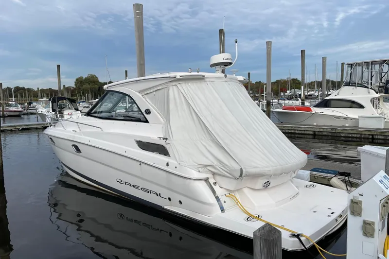 Slide: The Image of 2012 Regal 35 Sport Coupe docked at a marina under a cloudy sky. - 56