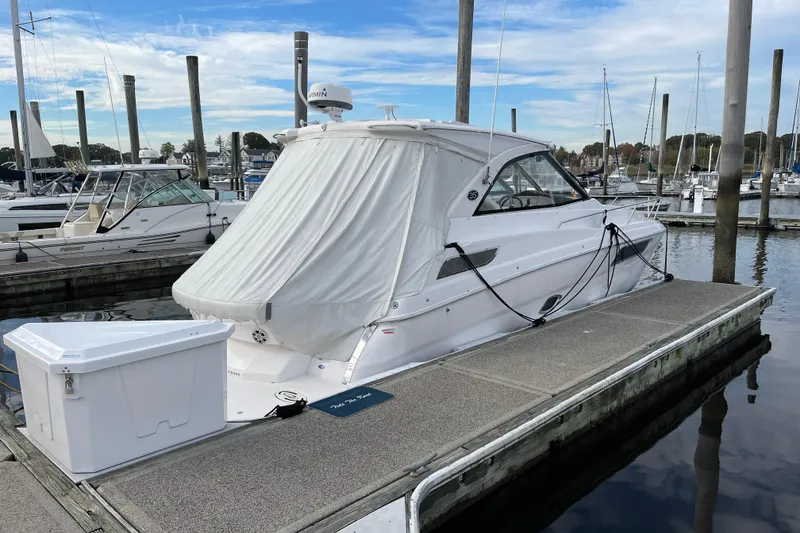 Slide: The Image of 2012 Regal 35 Sport Coupe docked at a marina, covered and secured with ropes. - 57