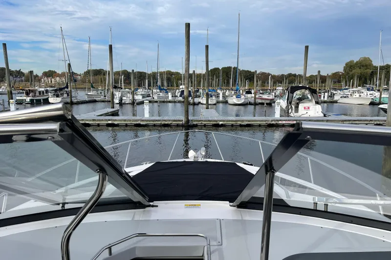 Slide: The Image of 2012 Regal 35 Sport Coupe docked at a marina with sailboats and clear skies. - 6