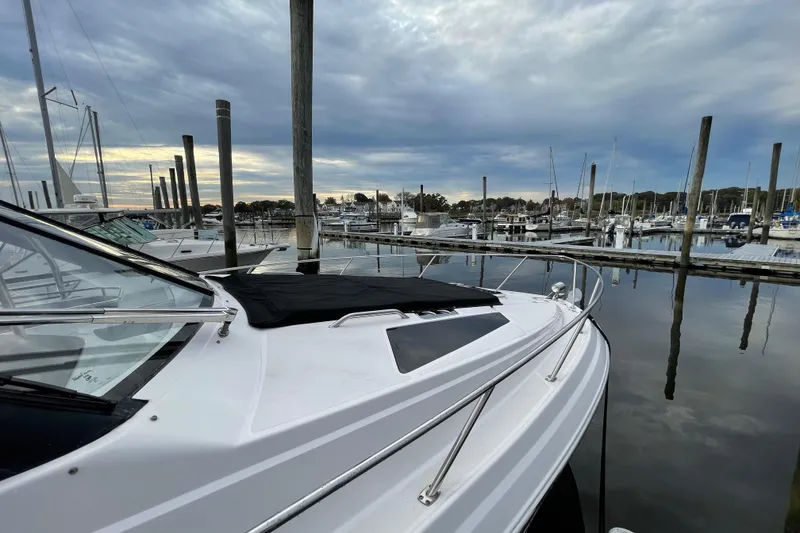 Slide: The Image of 2012 Regal 35 Sport Coupe docked in a serene marina under cloudy skies. - 8
