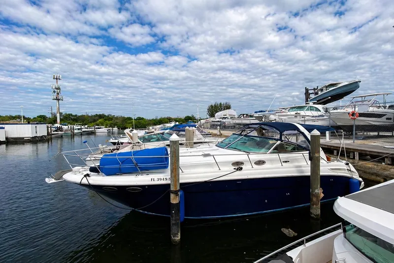 The Image of 2004 Sea Ray 380 Sundancer yacht docked at marina under cloudy sky. - 0