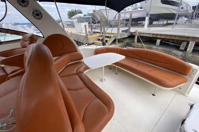 Slide: The Image of Luxurious 2004 Sea Ray 380 Sundancer yacht interior with brown leather seating and table. - 11