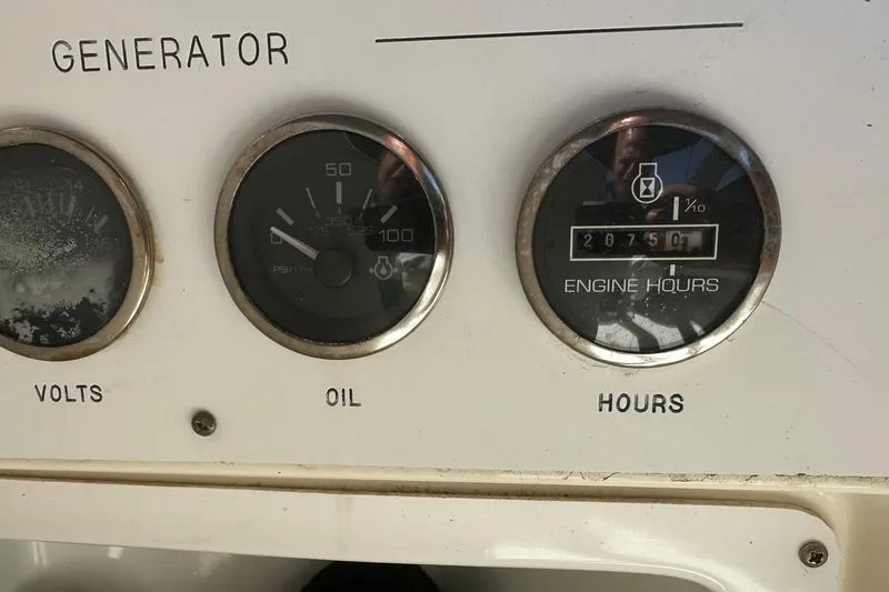 Slide: The Image of Generator panel with voltmeter, oil pressure gauge, and engine hours display on 2004 Sea Ray 380 Sundancer. - 19