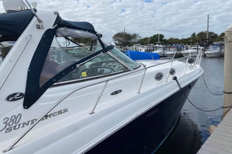 Slide: The Image of 2004 Sea Ray 380 Sundancer docked at marina, showcasing sleek design and luxury features. - 2
