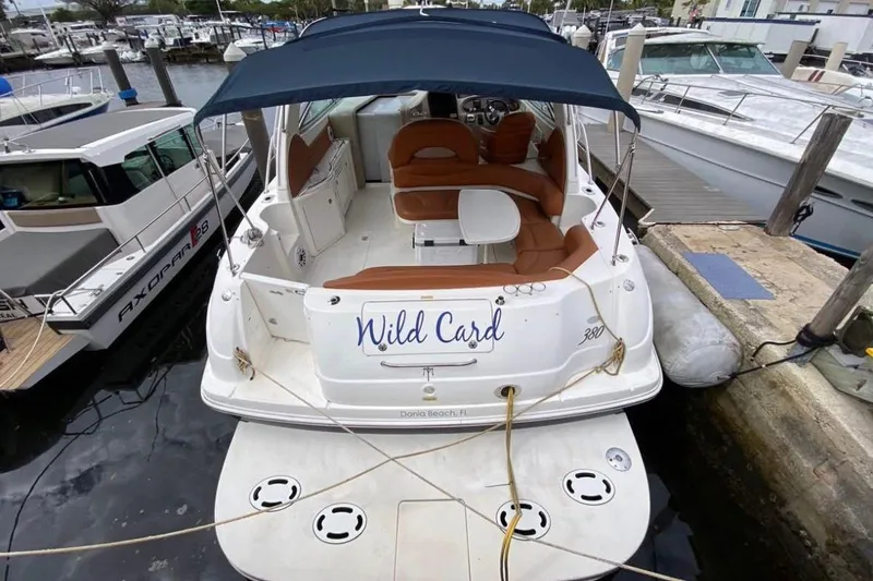 Slide: The Image of 2004 Sea Ray 380 Sundancer docked, featuring "Wild Card" name and spacious seating area. - 4