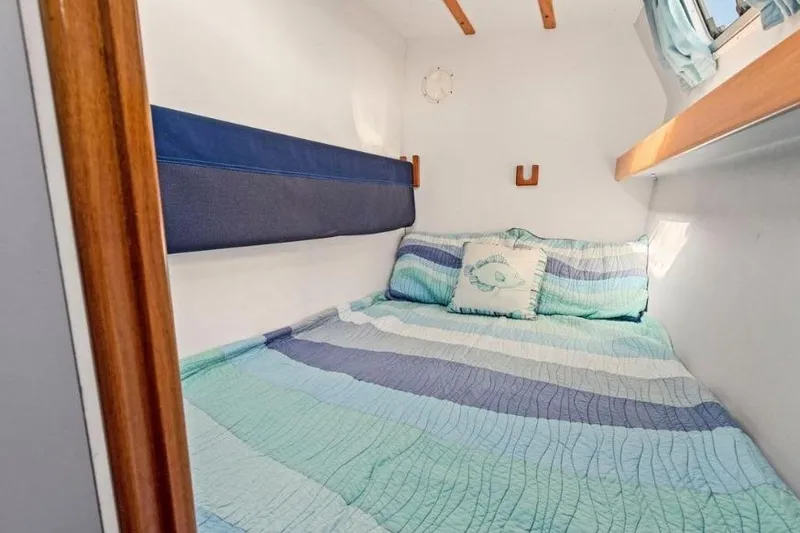 Slide: The Image of Cozy cabin interior of 2002 Outremer 55 Light with striped bedding. - 23