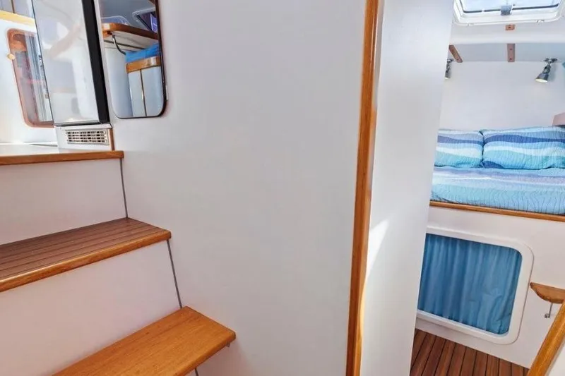 Slide: The Image of Interior of 2002 Outremer 55 Light yacht with wooden stairs and cozy bedroom. - 26