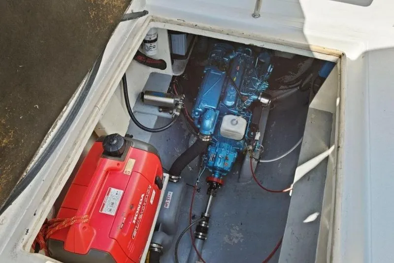 Slide: The Image of Engine compartment of a 2002 Outremer 55 Light catamaran, featuring a blue engine and red generator. - 34