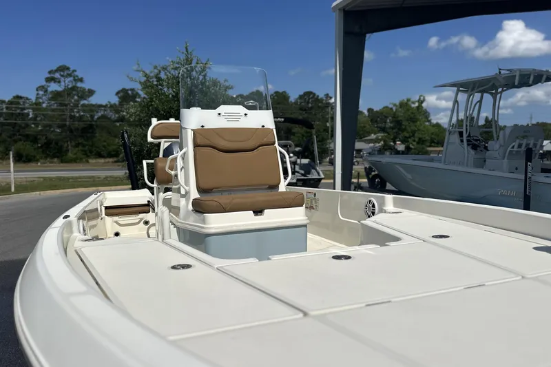 Slide: The Image of 2023 Skeeter SX210 boat with tan seating, showcased outdoors under clear skies. - 5