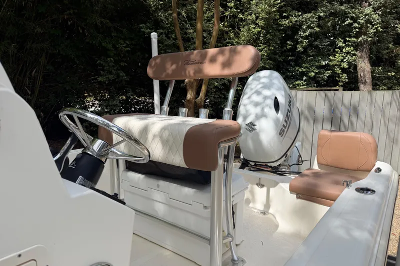 Slide: The Image of 2023 Pioneer 180 Islander boat interior with steering wheel and Suzuki engine. - 8