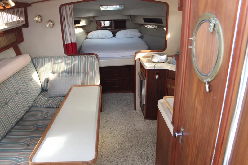 Slide: The Image of Interior of 1986 Searay 340 Express boat with cozy seating and sleeping area. - 10