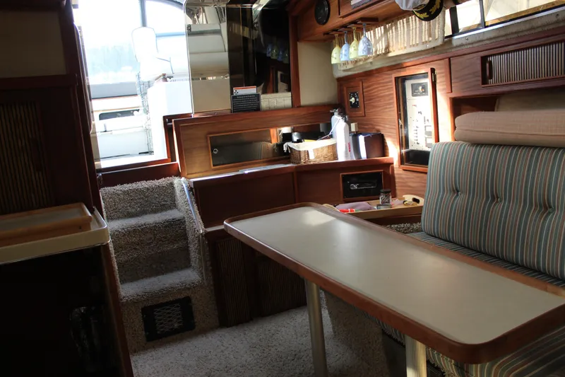 Slide: The Image of Interior of 1986 Searay 340 Express boat with cozy seating and wooden accents. - 17