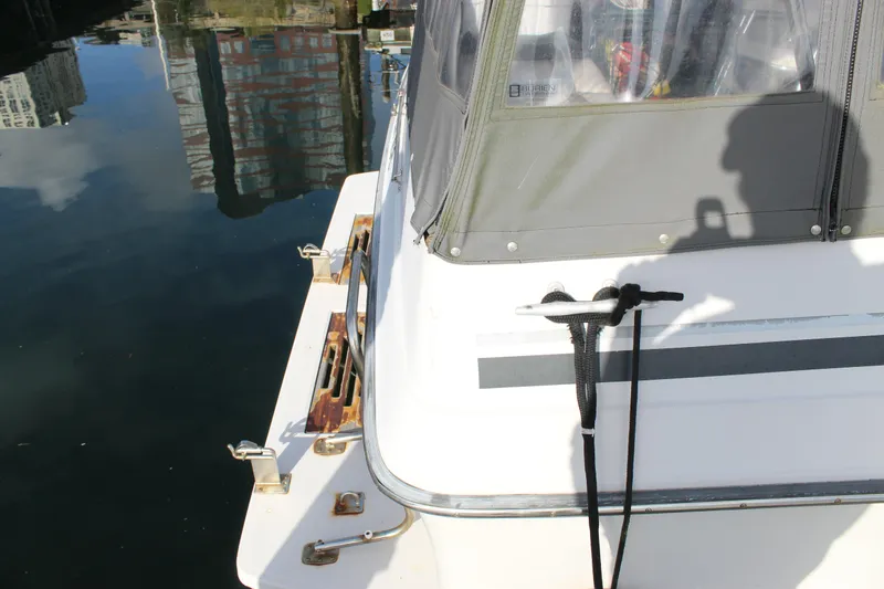 Slide: The Image of 1986 Searay 340 Express boat docked, showing stern details and water reflection. - 3