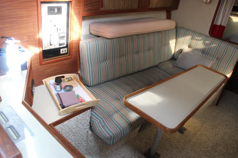 Slide: The Image of Interior of 1986 Searay 340 Express with striped seating and wooden table. - 9