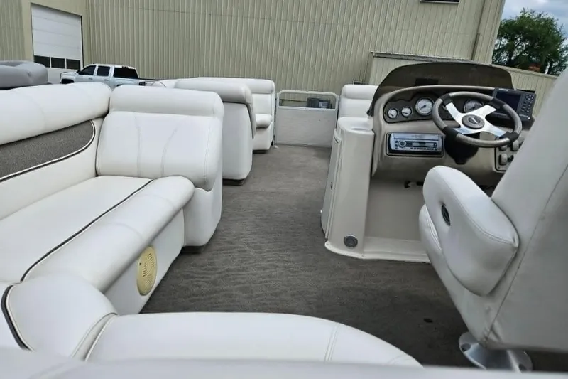 Slide: The Image of Interior of a 2007 Premier 225 Legend RE pontoon boat with white seating and steering console. - 6
