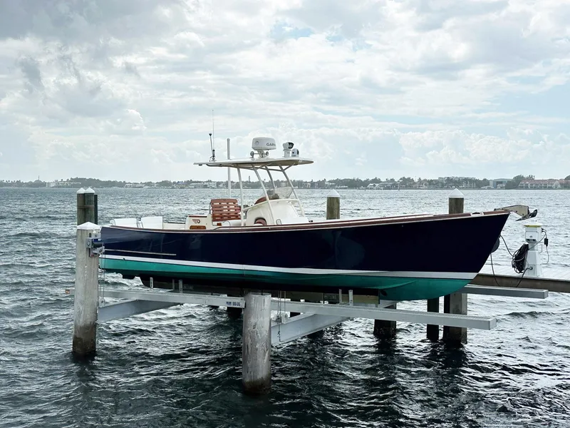Slide: The Image of Hinckley Talaria 29 C boat from 2002 on a lift over water. - 1