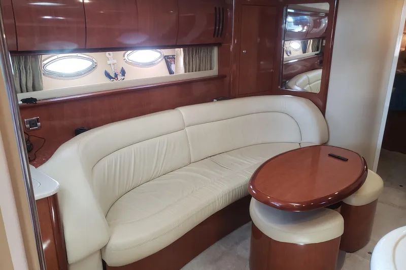 Slide: The Image of Luxurious interior of 2003 Sea Ray 420 Sundancer with cream leather seating and wooden table. - 17