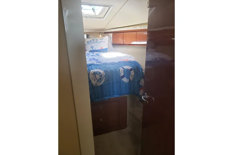 Slide: The Image of Interior of 2003 Sea Ray 420 Sundancer with nautical-themed bedding. - 22