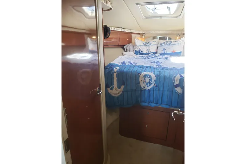 Slide: The Image of Interior of 2003 Sea Ray 420 Sundancer with nautical-themed bedding. - 23