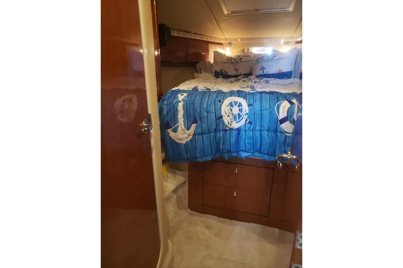 Slide: The Image of Interior of 2003 Sea Ray 420 Sundancer with nautical-themed bedding. - 24