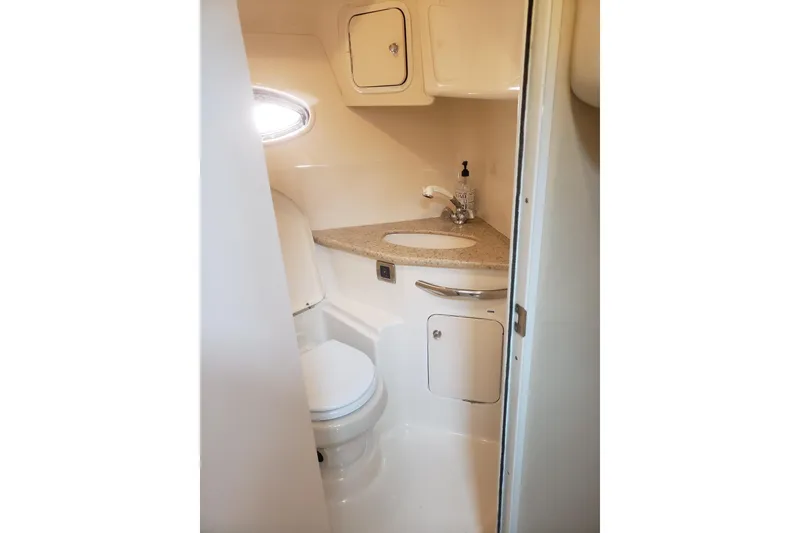 Slide: The Image of 2003 Sea Ray 420 Sundancer bathroom with sink, toilet, and storage cabinets. - 26