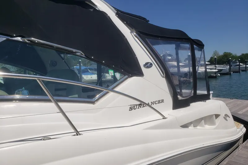 Slide: The Image of 2003 Sea Ray 420 Sundancer yacht docked at marina, featuring sleek design and black canopy. - 4