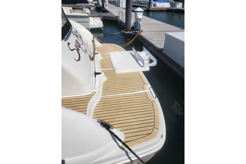 Slide: The Image of 2003 Sea Ray 420 Sundancer yacht docked, featuring a spacious teak swim platform. - 5