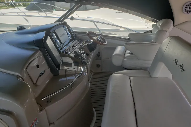 Slide: The Image of 2003 Sea Ray 420 Sundancer cockpit with leather seating and modern navigation controls. - 9