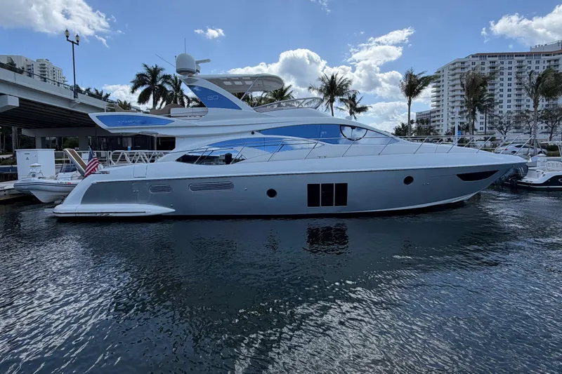 The Image of Luxury 2013 Azimut 60 yacht docked in a marina with palm trees and buildings. - 20
