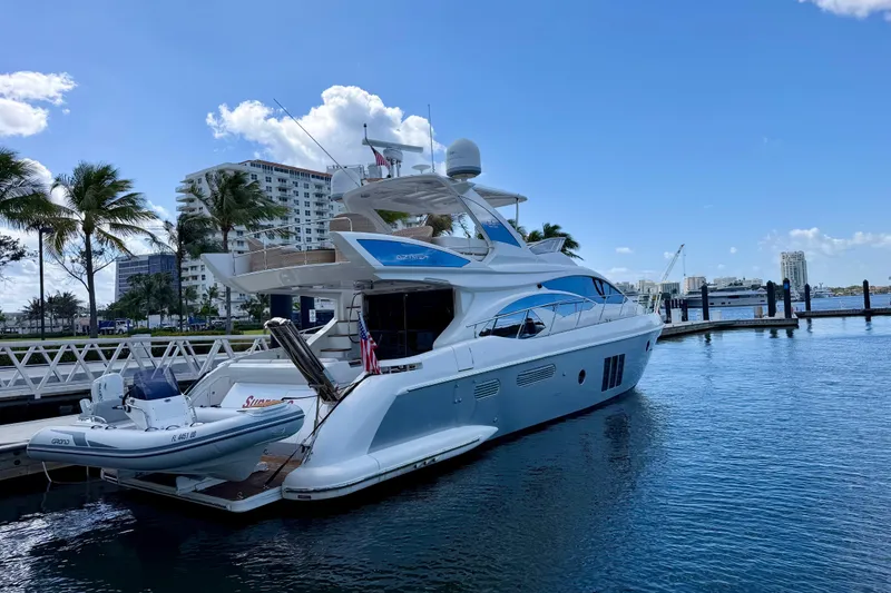 Slide: The Image of Luxurious 2013 Azimut 60 yacht docked at marina, surrounded by palm trees and cityscape. - 22
