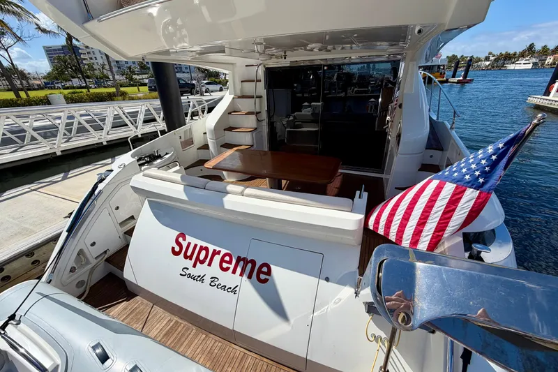 Slide: The Image of Azimut 60 yacht, 2013 model, docked with American flag and "Supreme South Beach" signage. - 45