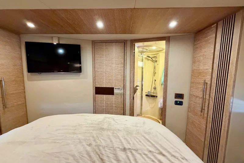 Slide: The Image of Luxurious 2013 Azimut 60 yacht bedroom with TV, ensuite bathroom, and elegant wood finishes. - 53